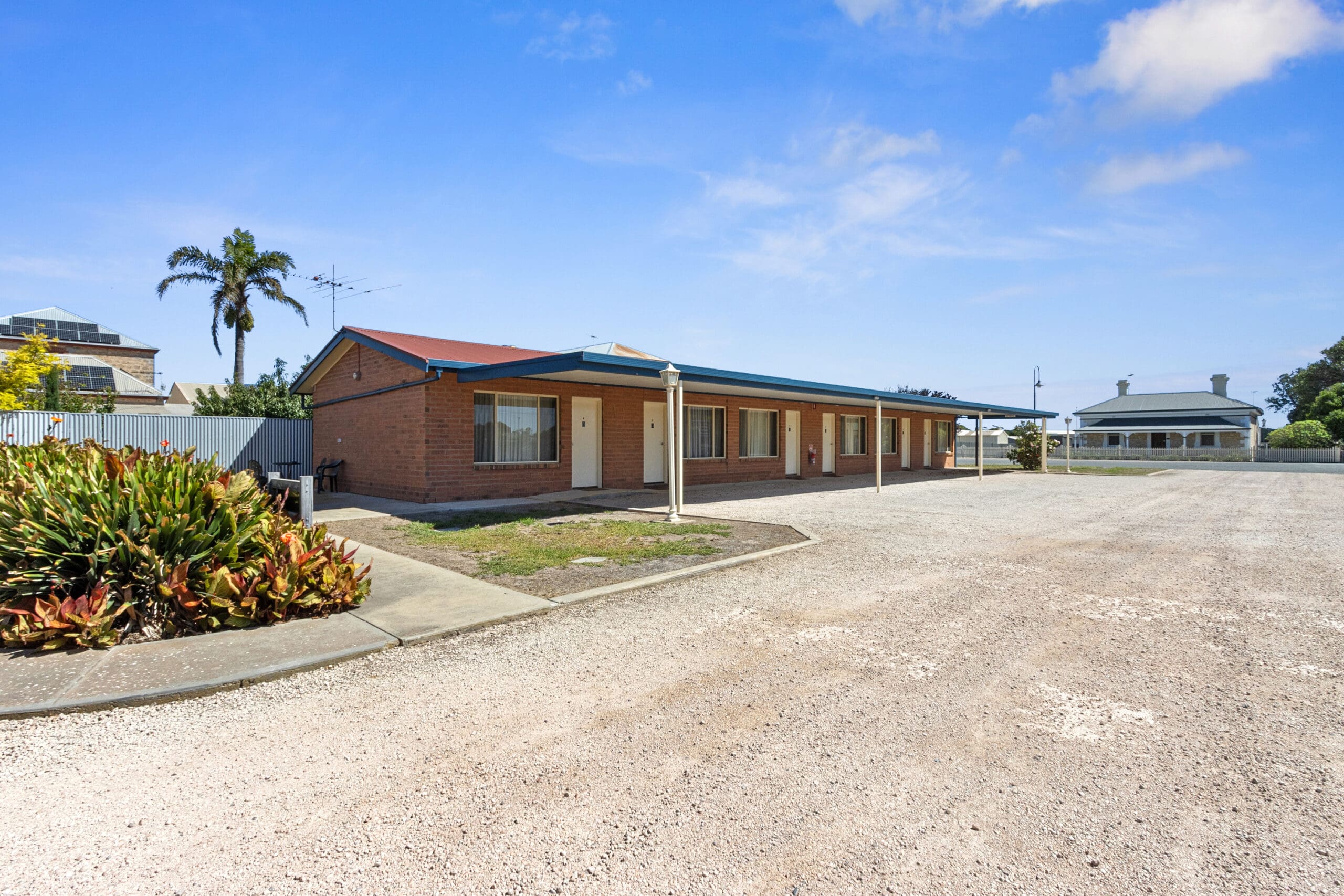 Edithburgh Seaside Motel, external view with landscaped gardens. Historical homestead in background.